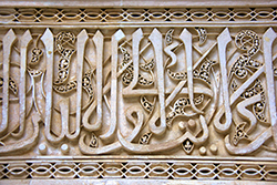 Arab calligraphy of a quran verse, carved in wood at a mosque in Fes, Morocco.